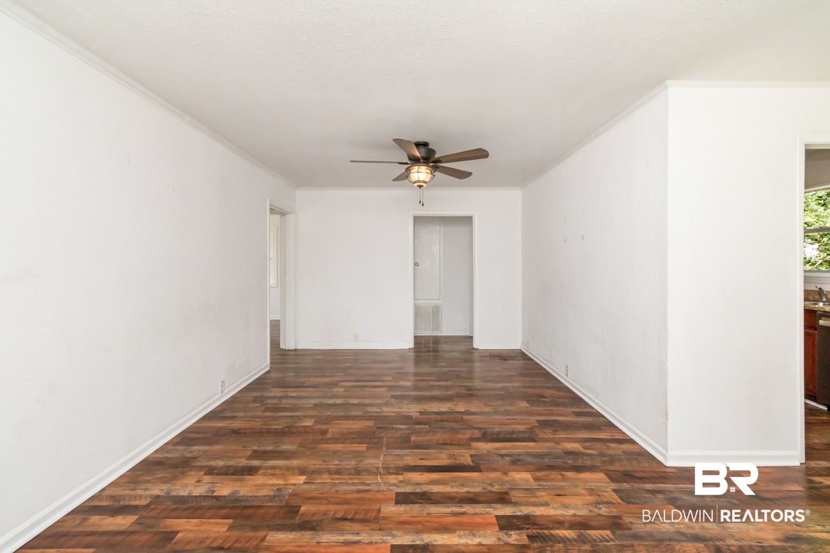 2905A McFarland Road, Unit F Mobile, AL 36695 - Photo 5 of 29 Spacious room featuring wood-finish flooring, white walls, and a ceiling fan with integrated lighting