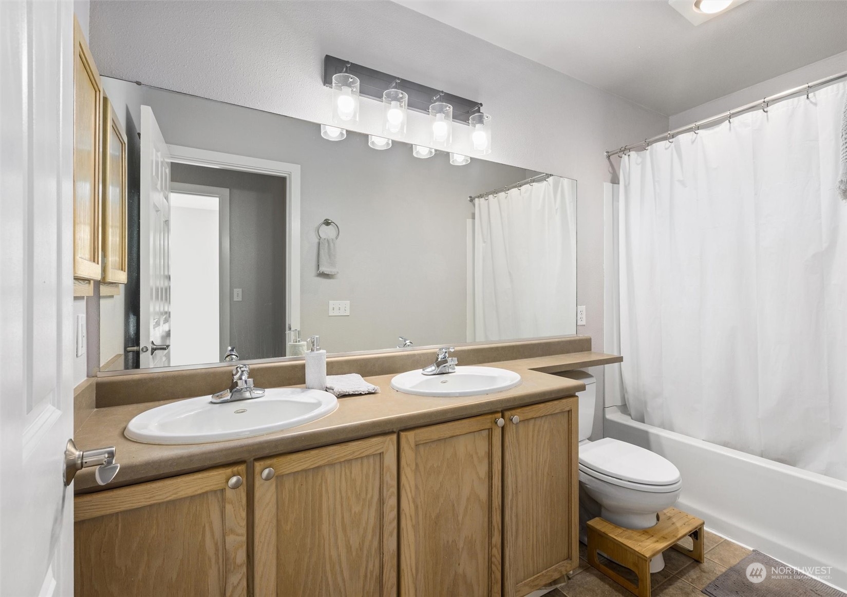 18930 Bothell Everett Highway, Unit C106 Bothell, WA 98012 - Photo 12 of 20 a bathroom with a granite countertop sink toilet a mirror and a shower
