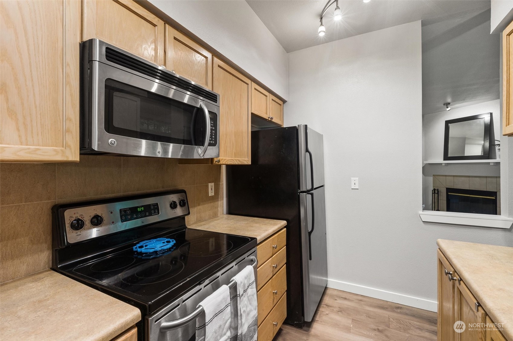 18930 Bothell Everett Highway, Unit C106 Bothell, WA 98012 - Photo 6 of 20 a kitchen with stainless steel appliances granite countertop a stove microwave and refrigerator