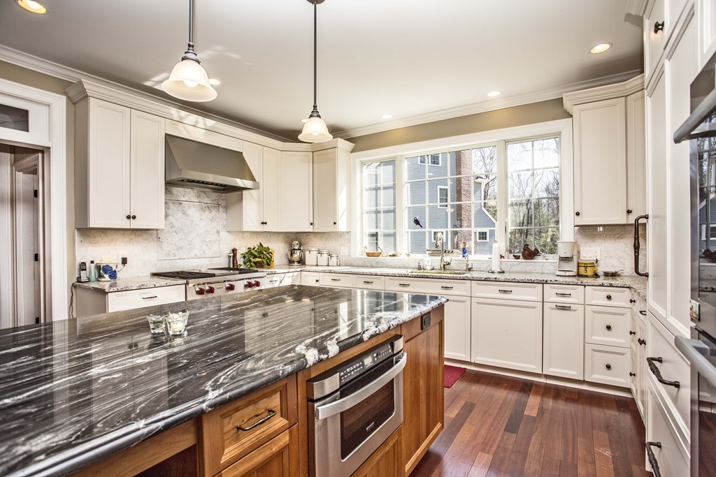 70 Deerfield Road Needham, MA 02492 - Photo 3 of 19 a kitchen with stainless steel appliances kitchen island granite countertop a stove a sink and white cabinets with wooden floor