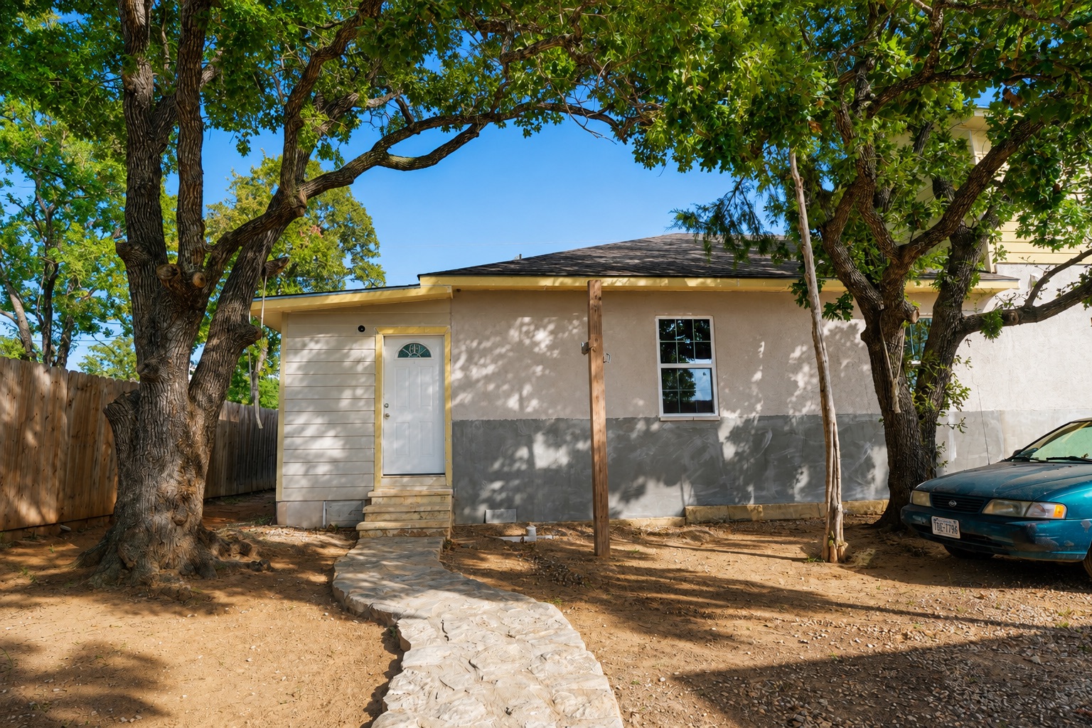 158 Buena Fortuna Road Elgin, TX 78621 - Photo 24 of 40 A quaint residence framed by mature trees, features a welcoming stone pathway leading to the entry.