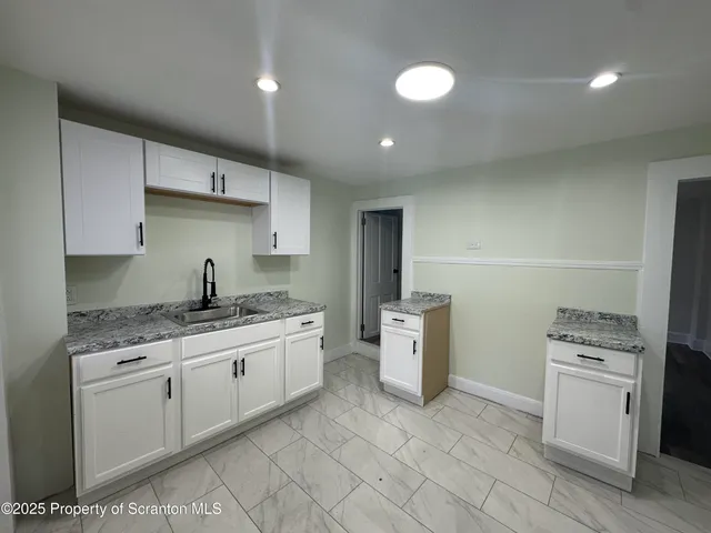 a kitchen with stainless steel appliances granite countertop a sink and cabinets