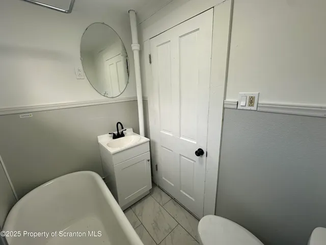 a bathroom with a toilet a sink and a mirror
