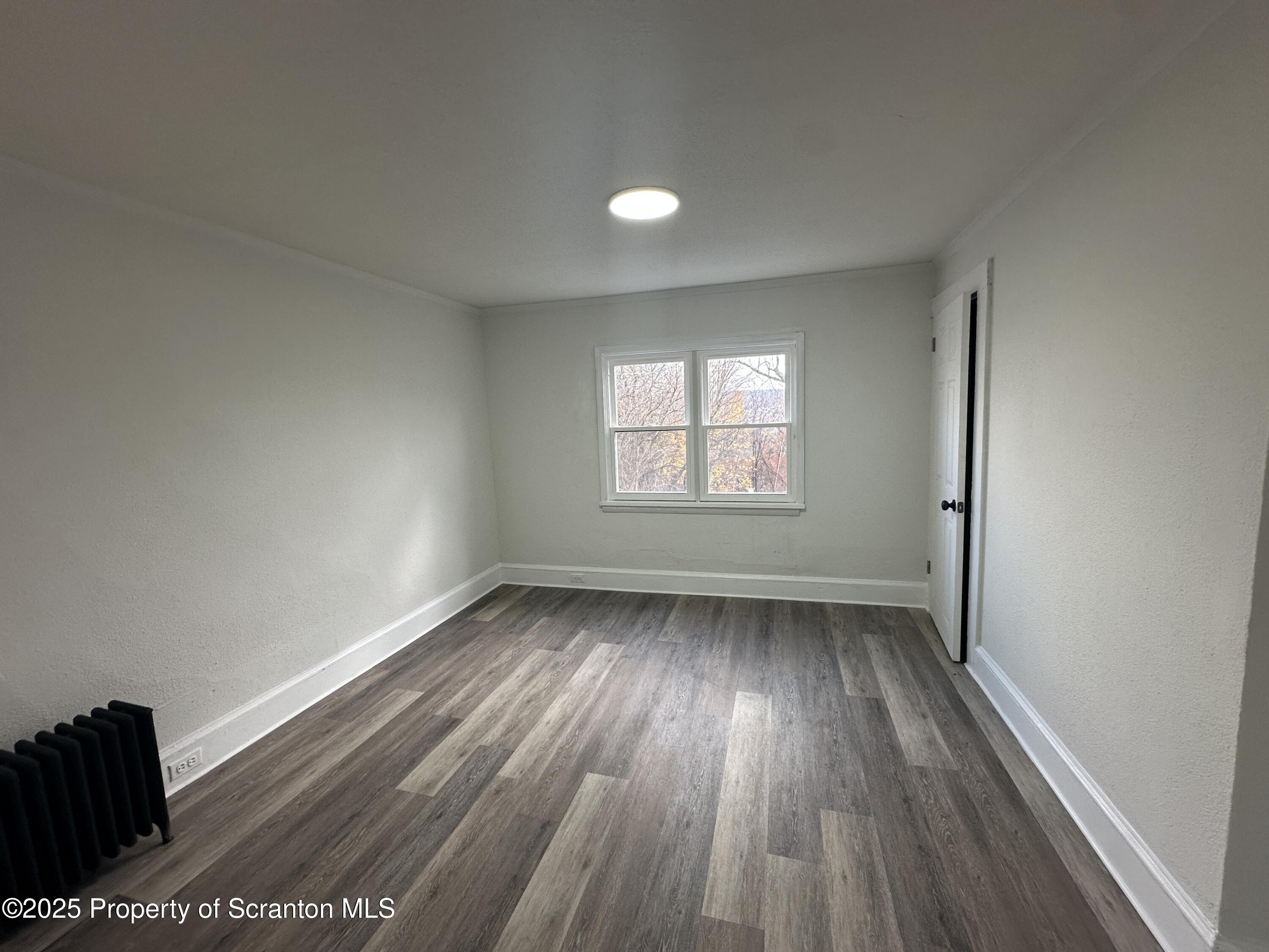 1264 South 6th Avenue, Unit 2 Scranton, PA 18504 - Photo 5 of 11 an empty room with wooden floor and windows