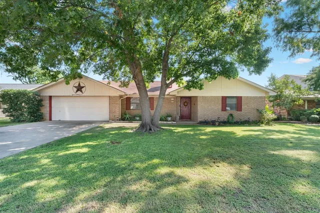 a front view of a house with a garden and yard