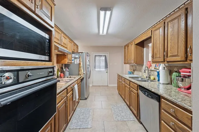 a kitchen with stainless steel appliances a sink stove and cabinets