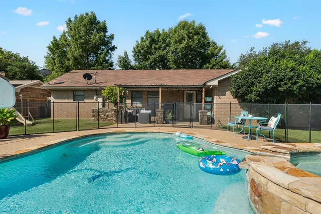 a front view of a house with swimming pool garden and patio