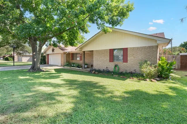 a view of backyard of house with green space