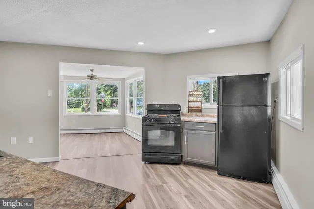 a kitchen with a refrigerator and a stove top oven