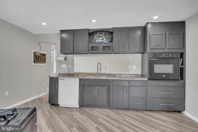 a kitchen with granite countertop white cabinets and stainless steel appliances