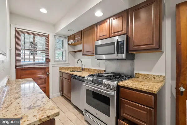 a kitchen with stainless steel appliances granite countertop a stove microwave and sink
