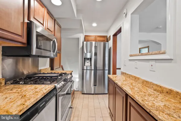 a kitchen with stainless steel appliances granite countertop a stove a refrigerator and a oven