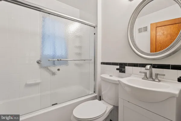 a bathroom with a sink a toilet and a mirror