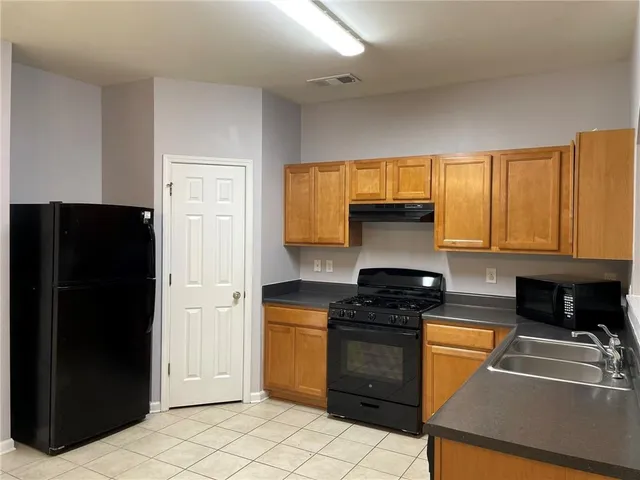 a kitchen with granite countertop a stove and a refrigerator