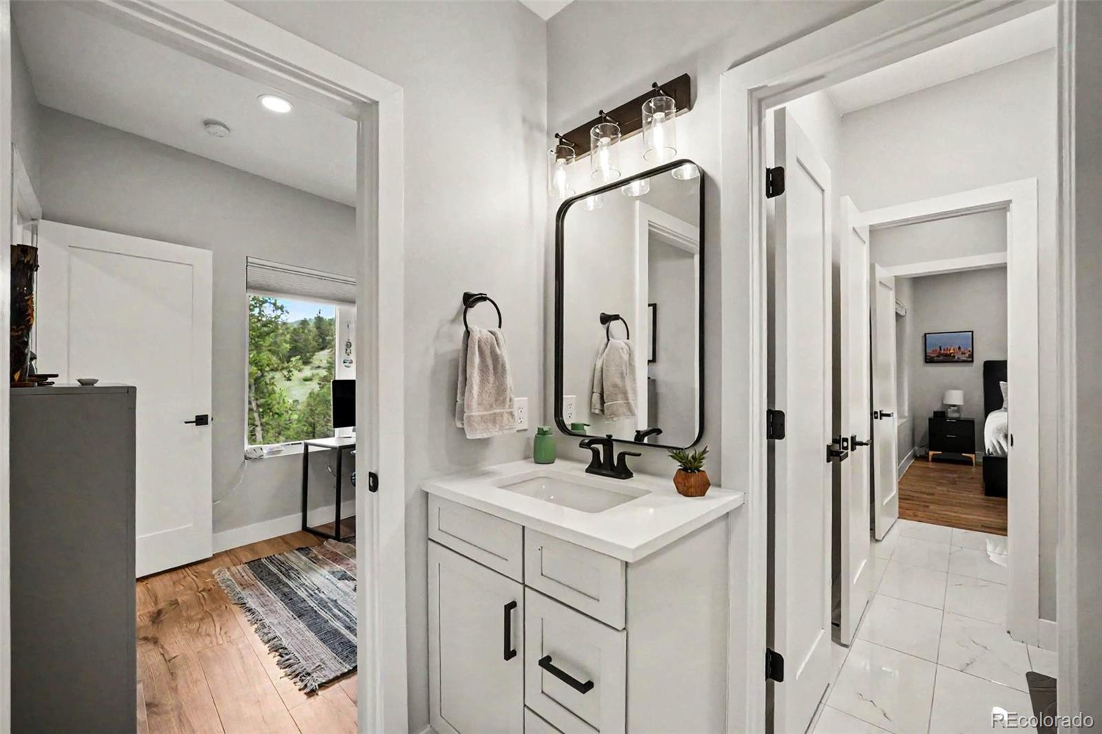 7231 Timber Trail Road Evergreen, CO 80439 - Photo 22 of 35 a bathroom with a sink vanity and a mirror