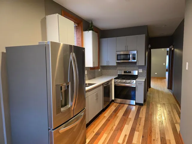 a kitchen with stainless steel appliances granite countertop a refrigerator and a stove