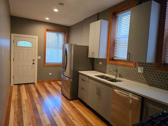 a kitchen with a sink and wooden floor