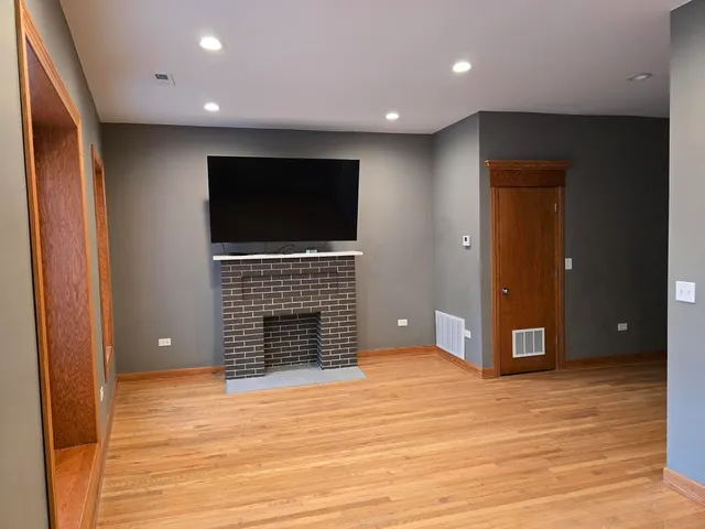 an empty room with wooden floor and fireplace