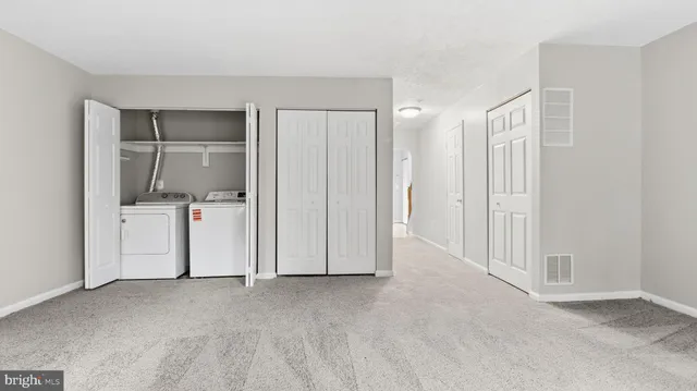 a view of an empty room with window and stairs