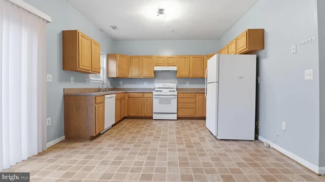 a kitchen with a refrigerator sink and cabinets