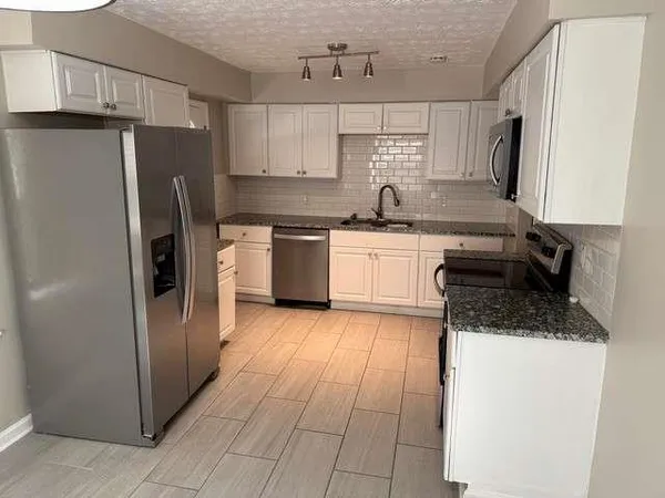 a kitchen with a refrigerator sink and stove