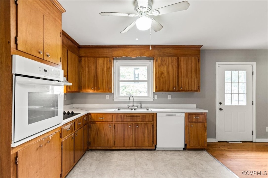 7801 Bull Hill Road Prince George, VA 23875 - Photo 12 of 49 Kitchen with white appliances, brown cabinetry, an