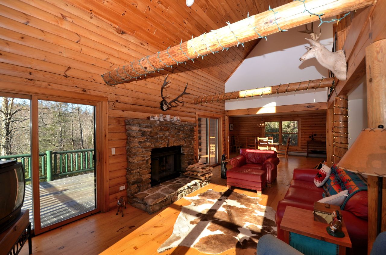 697 Woodmere Road Becket, MA 01223 - Photo 9 of 23 a living room with furniture a fireplace and a table