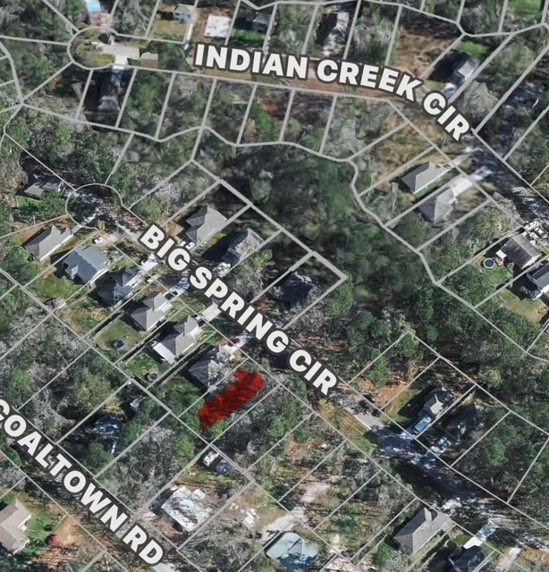 Na Big Spring Circle Willis, TX 77378 - Photo 2 of 2 This aerial view highlights a residential area with a wooded lot for sale on Big Spring Cir. The neighborhood is surrounded by greenery, providing a peaceful environment. Nearby roads include Indian Creek Cir and Coaltown Rd, offering easy access to local amenities and transportation routes.