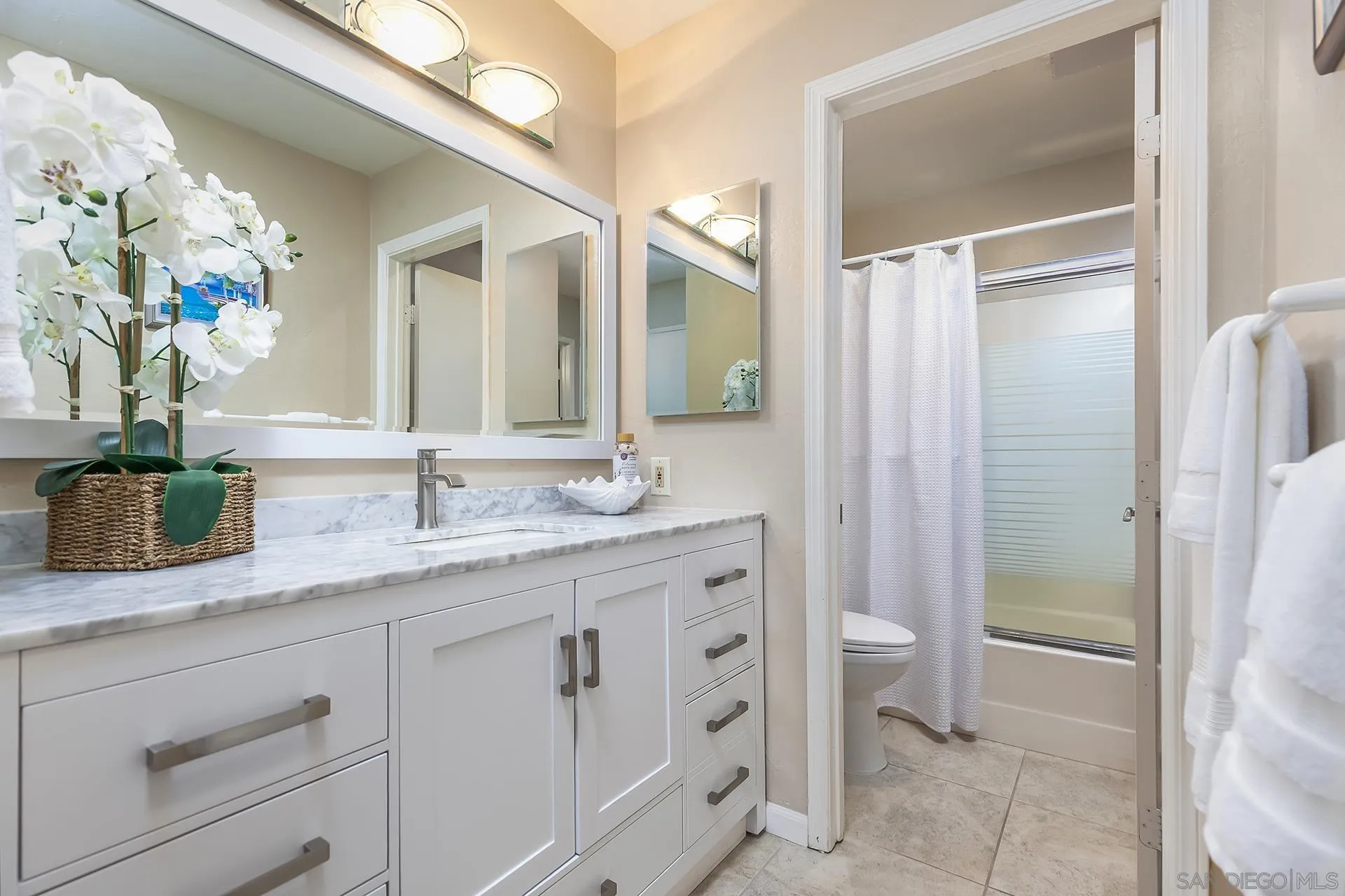4878 Pescadero Avenue, Unit 103 San Diego, CA 92107 - Photo 33 of 72 a bathroom with a granite countertop sink a toilet and a mirror