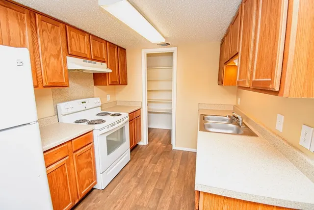 a kitchen with stainless steel appliances a stove a sink and a refrigerator
