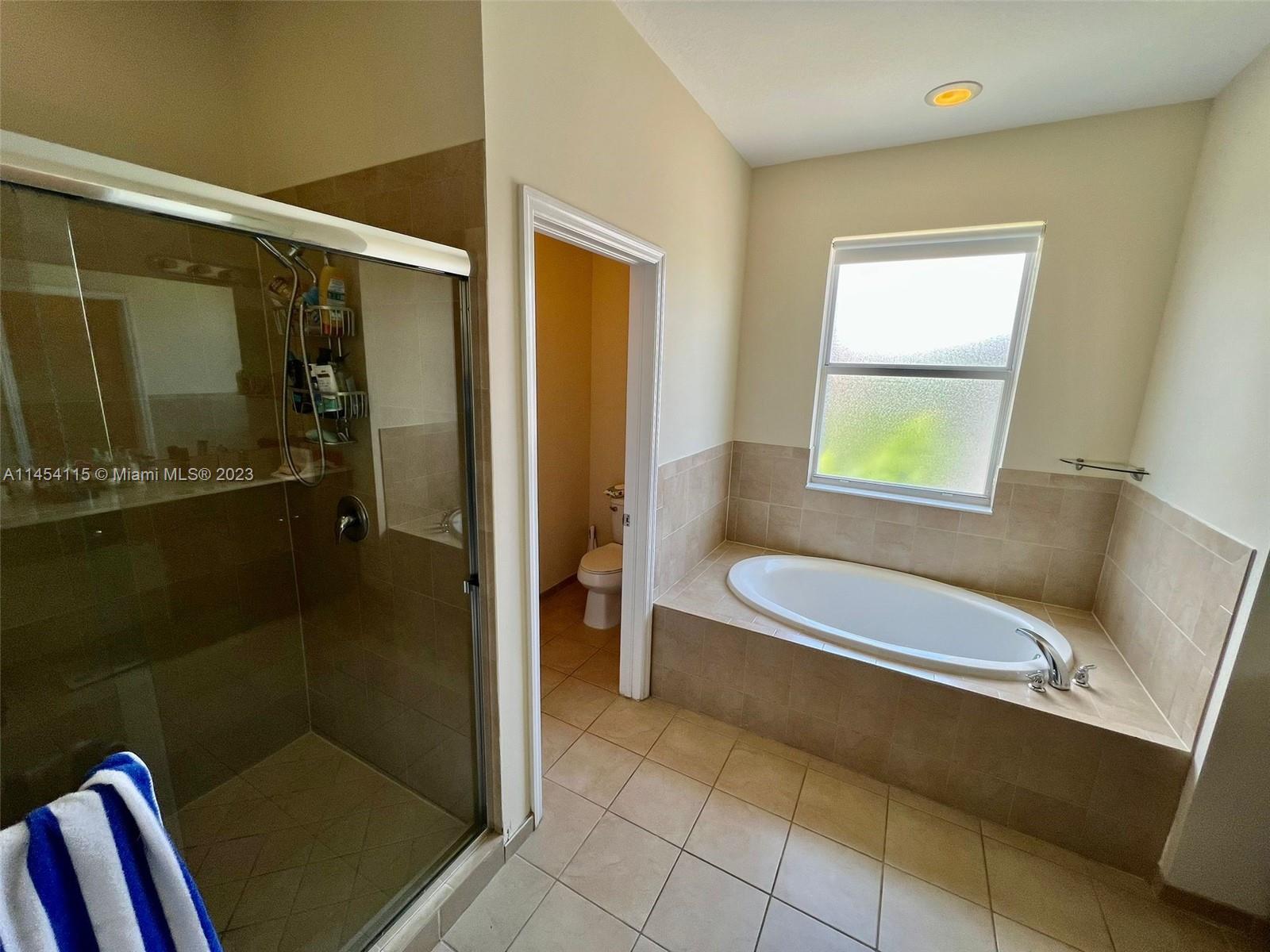 17182 Southwest 92nd Street Miami, FL 33196 - Photo 11 of 46 a bathroom with a tub a window and a shower