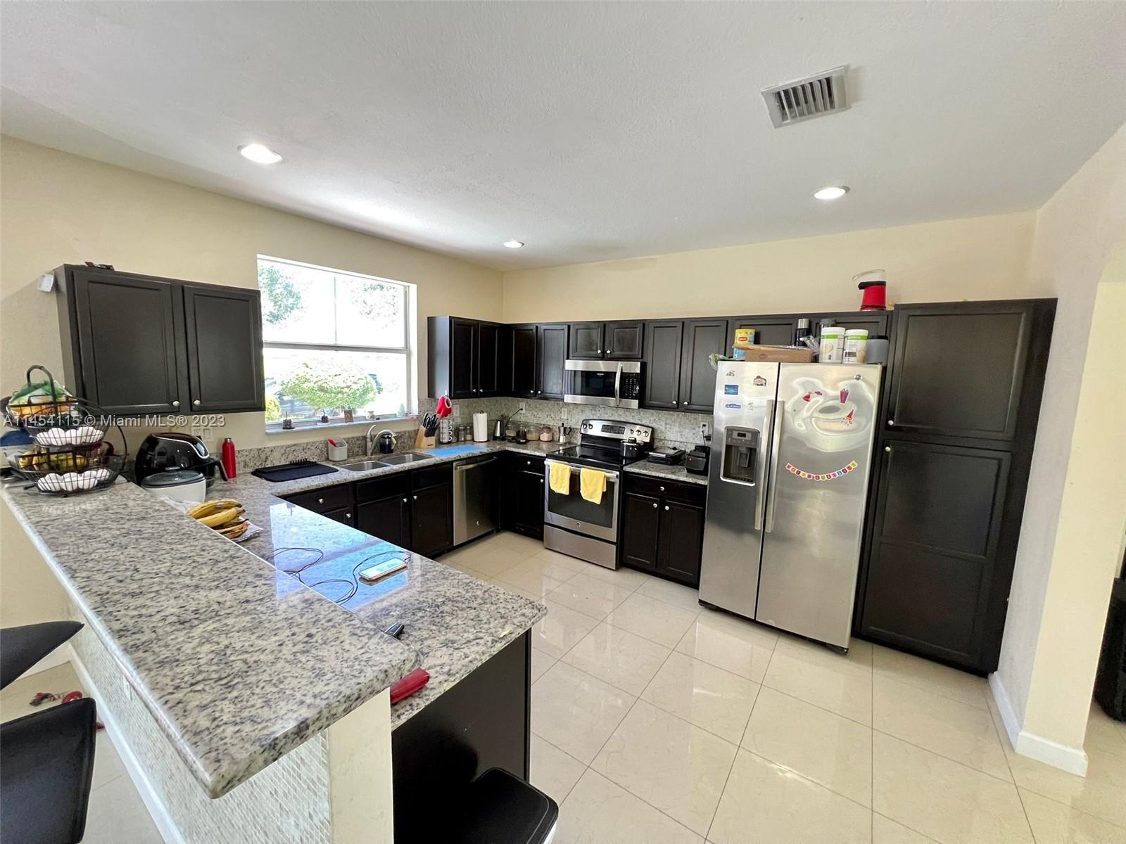 17182 Southwest 92nd Street Miami, FL 33196 - Photo 14 of 46 a kitchen with a refrigerator sink and microwave