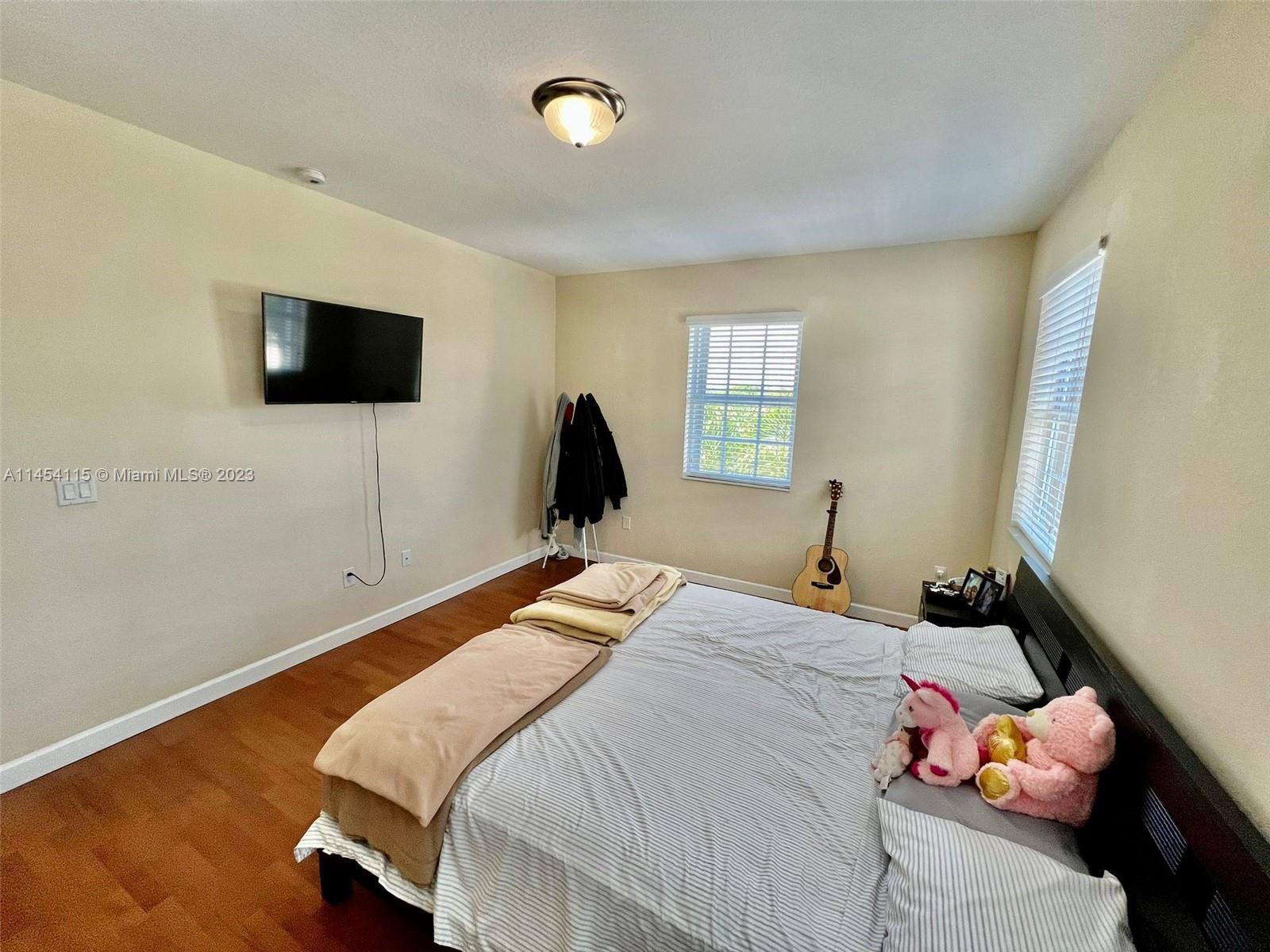 17182 Southwest 92nd Street Miami, FL 33196 - Photo 20 of 46 a bedroom with a bed and a flat screen tv