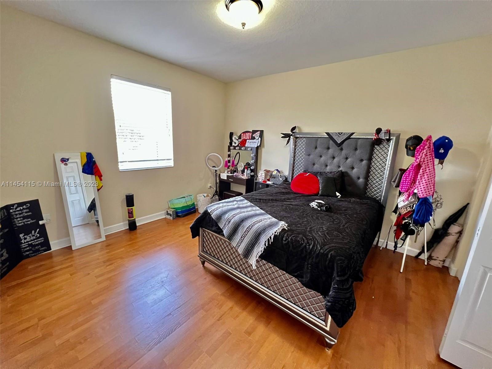 17182 Southwest 92nd Street Miami, FL 33196 - Photo 34 of 46 a bedroom with a bed and wooden floor