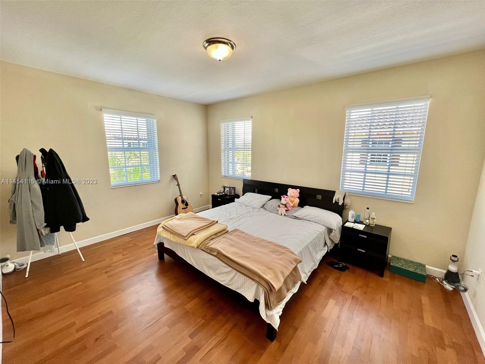 17182 Southwest 92nd Street Miami, FL 33196 - Photo 38 of 46 a bedroom with a bed and wooden floor