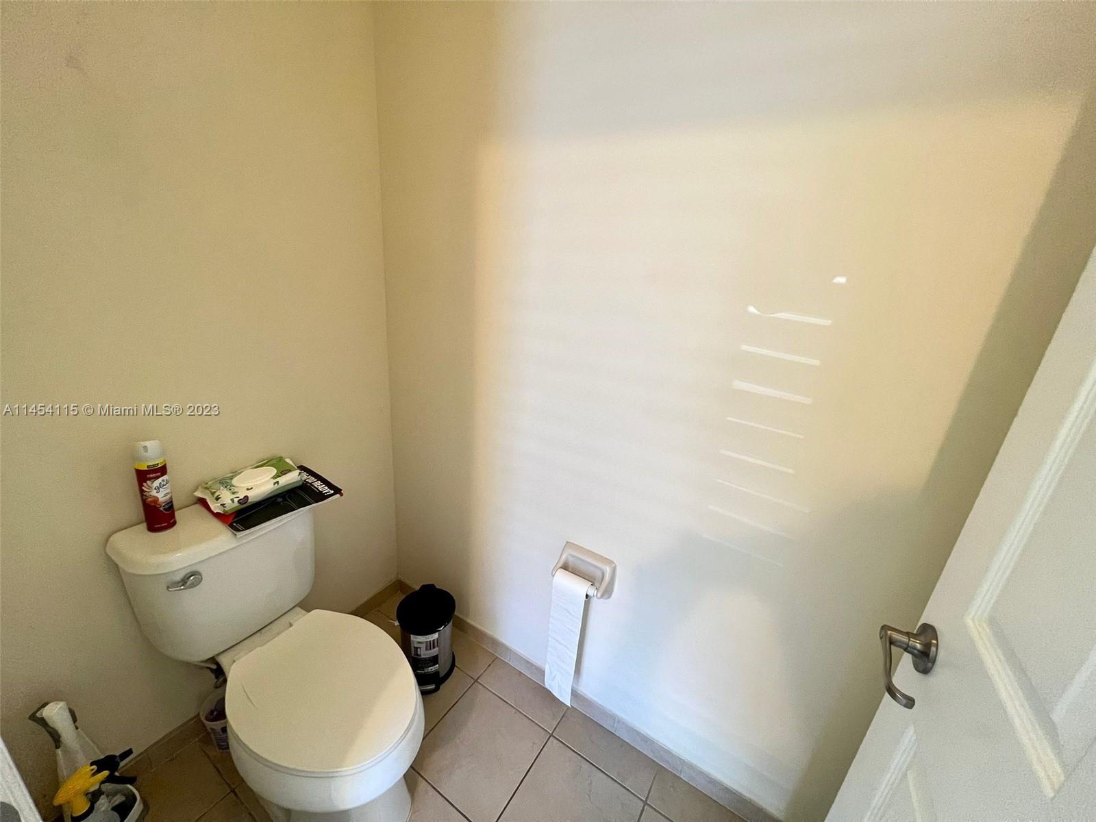 17182 Southwest 92nd Street Miami, FL 33196 - Photo 39 of 46 a white toilet sitting next to a wooden cabinet