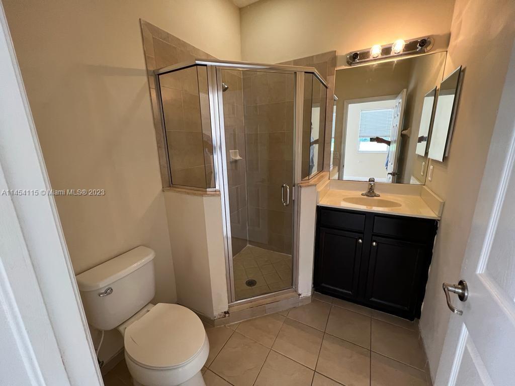 17182 Southwest 92nd Street Miami, FL 33196 - Photo 43 of 46 a bathroom with a double vanity sink toilet and shower