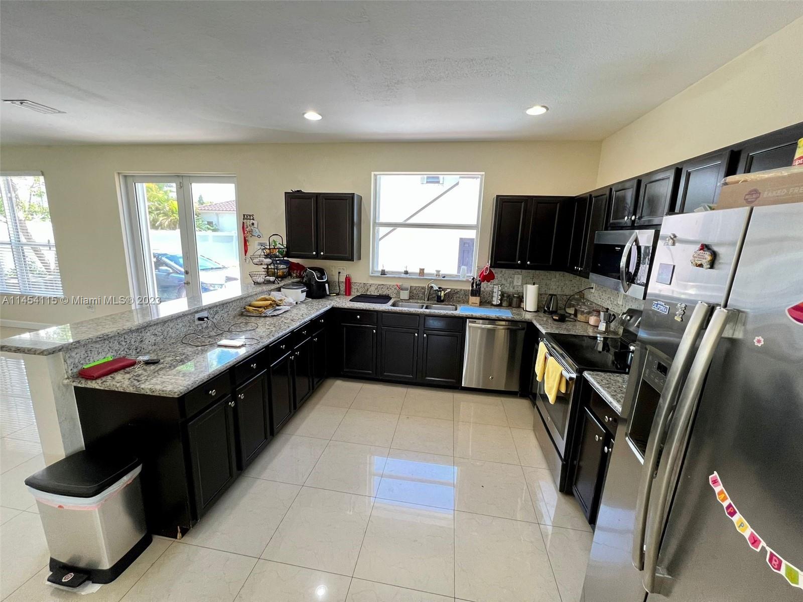 17182 Southwest 92nd Street Miami, FL 33196 - Photo 8 of 46 a kitchen with stainless steel appliances granite countertop a sink stove and refrigerator