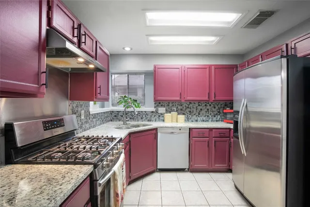 a kitchen with stainless steel appliances granite countertop a stove a refrigerator and a stove