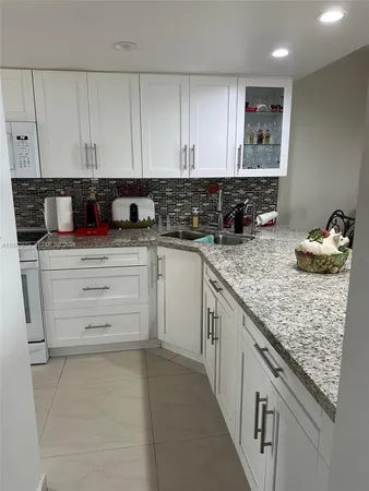 a kitchen with granite countertop a sink and cabinets