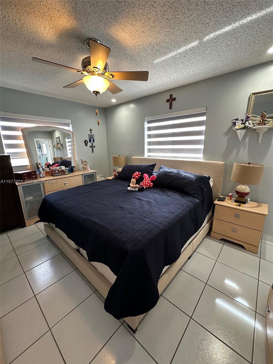 2385 West 69th Street, Unit 2385A Hialeah, FL 33016 - Photo 18 of 22 a bedroom with a bed and a chandelier