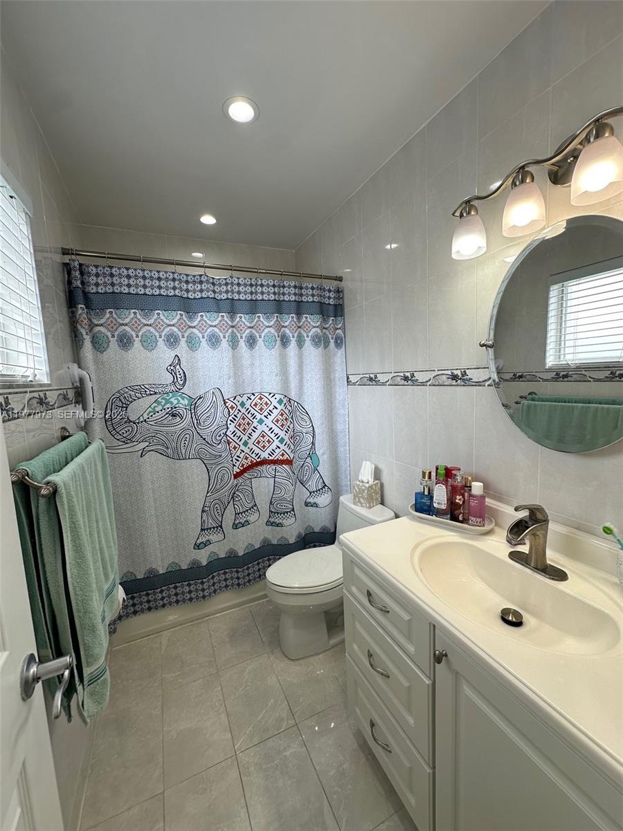 2385 West 69th Street, Unit 2385A Hialeah, FL 33016 - Photo 19 of 22 a bathroom with a sink toilet and mirror