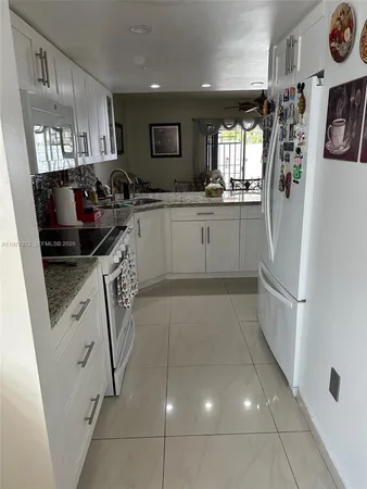 a kitchen with stainless steel appliances granite countertop a refrigerator and a stove