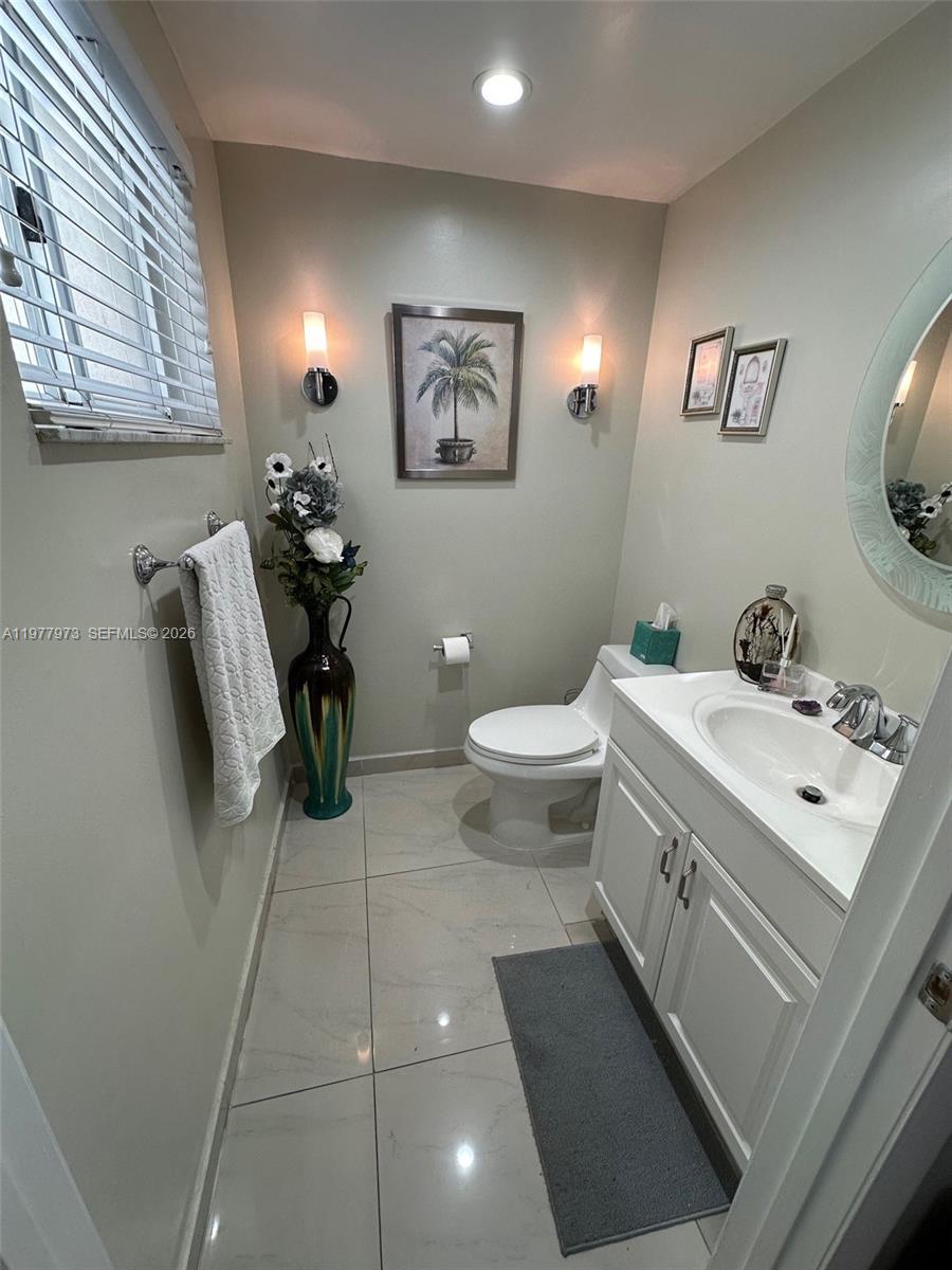 2385 West 69th Street, Unit 2385A Hialeah, FL 33016 - Photo 9 of 22 a bathroom with a toilet sink and mirror
