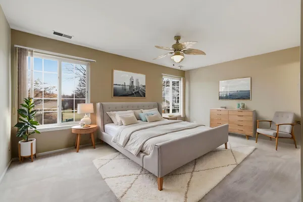 a spacious bedroom with a large bed and a chandelier