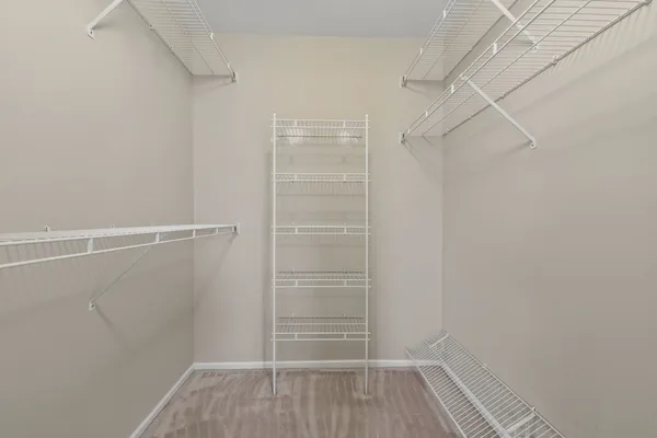a view of walk in closet with empty racks