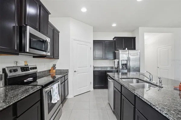 a kitchen with granite countertop a stove and a microwave