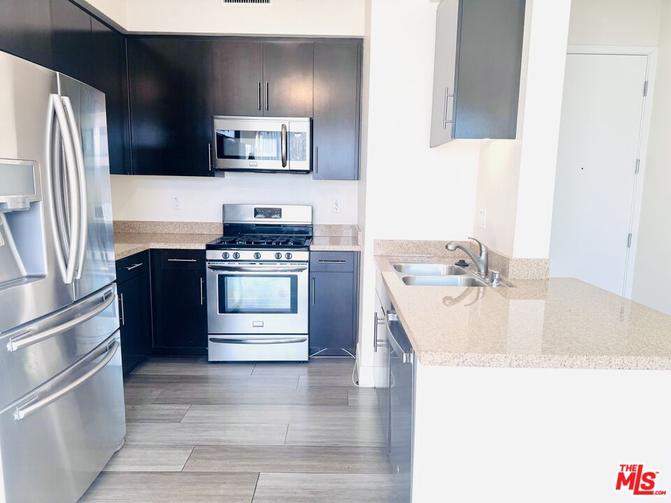 1241 5th Street, Unit 502 Santa Monica, CA 90401 - Photo 20 of 33 a kitchen with stainless steel appliances granite countertop a sink stove and refrigerator