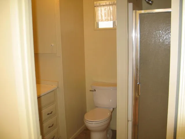 a bathroom with a granite countertop toilet and a sink