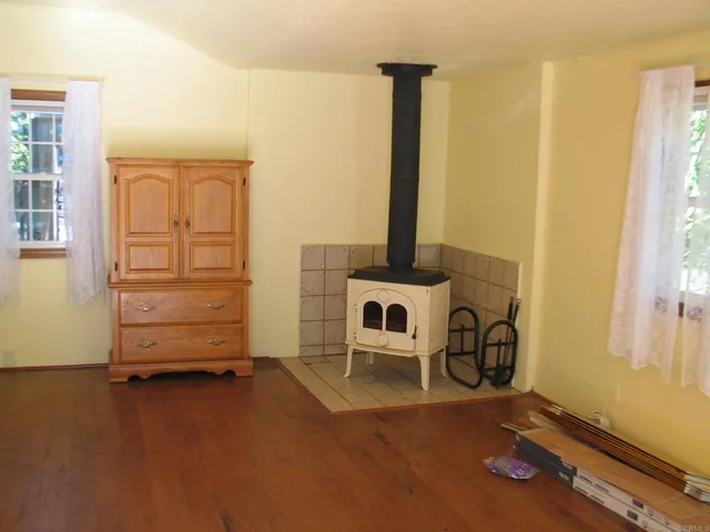 a view of an empty room with furniture and a window
